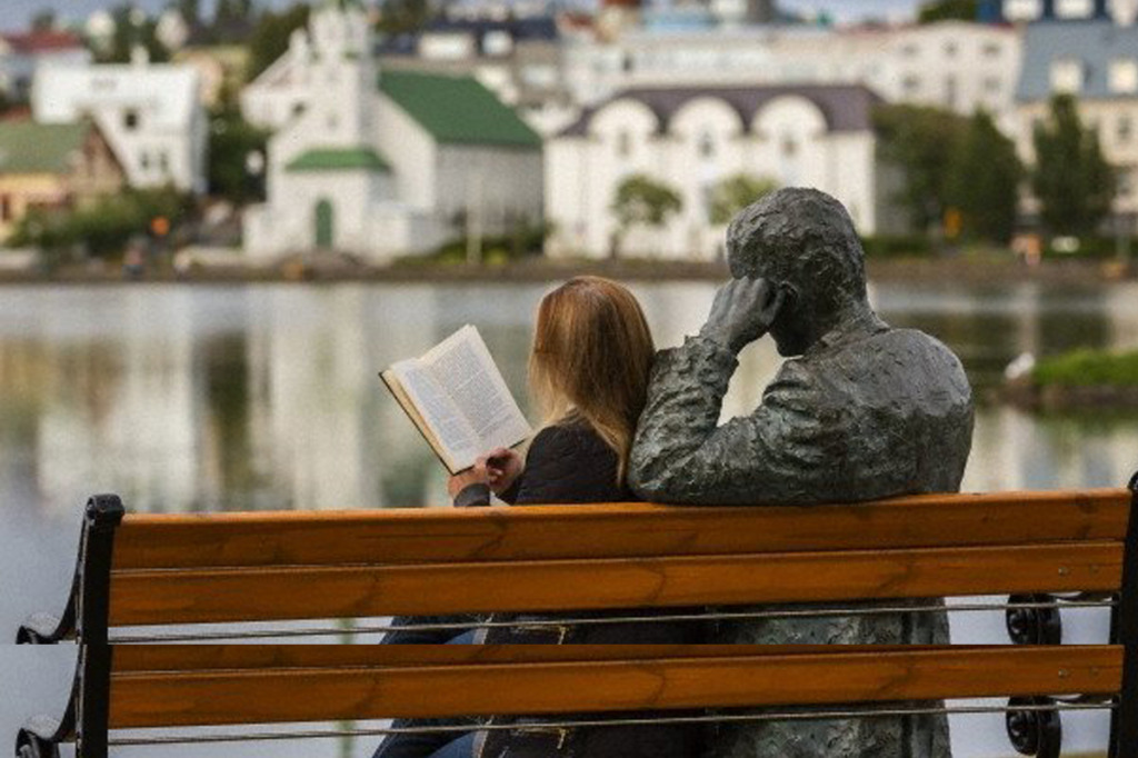 <a id="longdesc-return-5"></a> Lectora en el estanque lago Tjörn de la capital islandesa, Reikiavik.